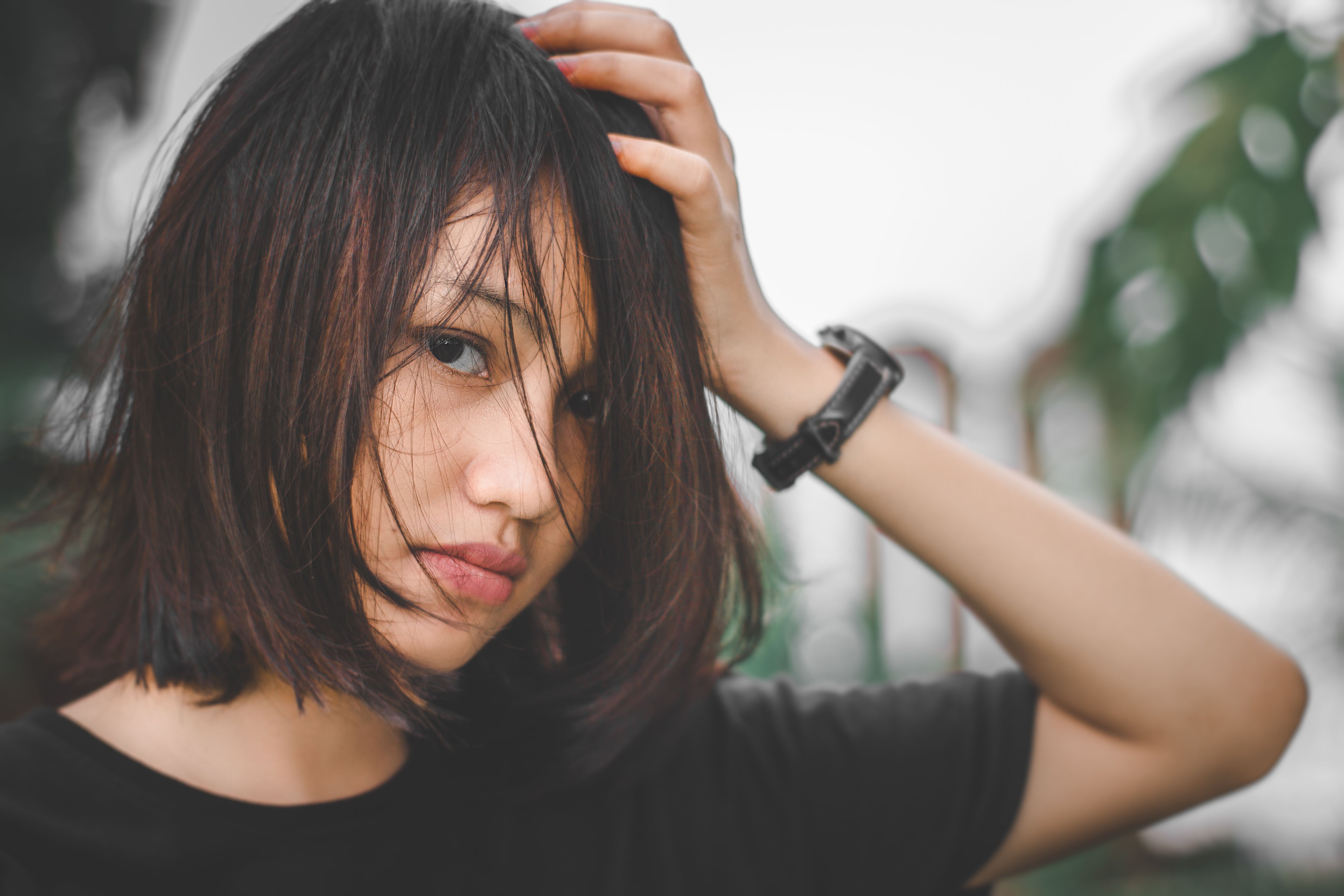Close-up portrait of a young woman with messy hair, outdoors in Banten, Indonesia.