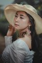 Woman in White Off Shoulder Dress Wearing Brown Sun Hat
