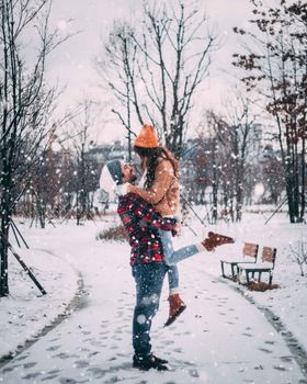 一对夫妇在首尔的一个公园里享受雪天，感受冬天的快乐与浪漫