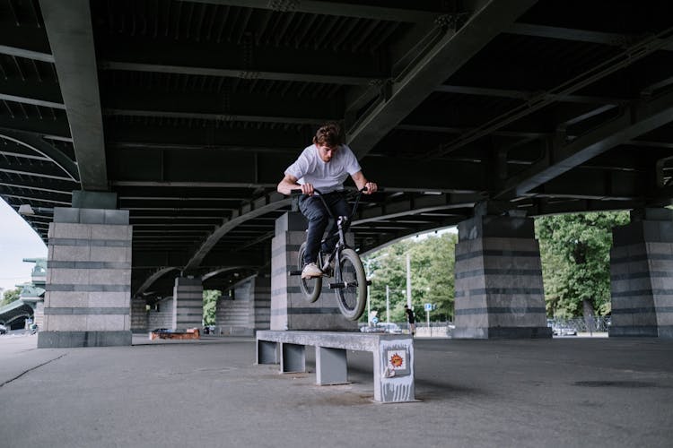 Man Riding A Bike On A Bench