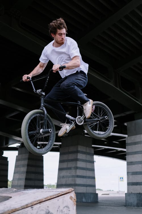 Man Riding a Bike Over a Ramp · Free Stock Photo