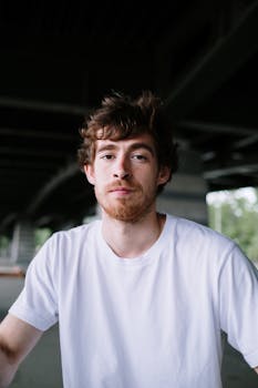 桥下有个穿着白衬衫、留着胡须的年轻人