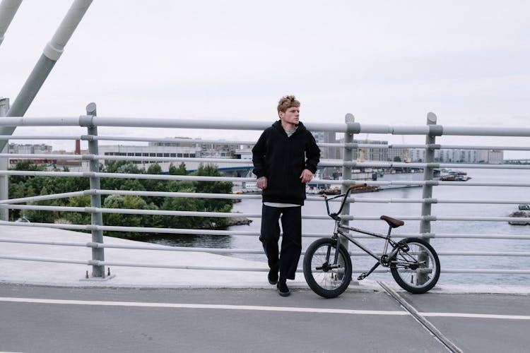 Man With A Bike Standing At A Bridge