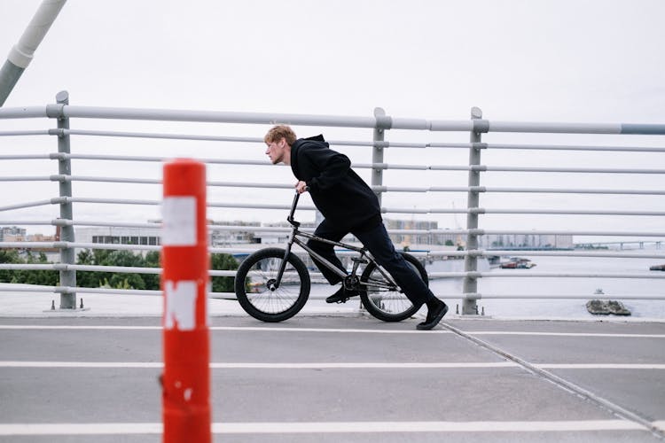 Man Riding A Bike At A Bridge