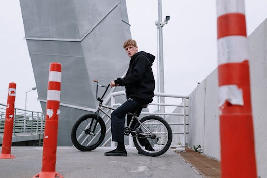 Urban scene of a young man on a BMX bike on a bridge.