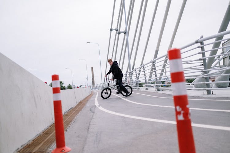 Man In Black Jacket Riding A Bicycle On Road