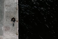 A Man in Black Hoodie Riding a Bicycle