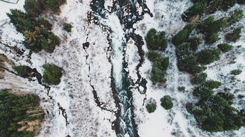 Aerial View of Flowing Water in a Snowy Mountain