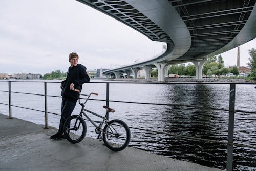 Man with a Bike Leaning on the Railing