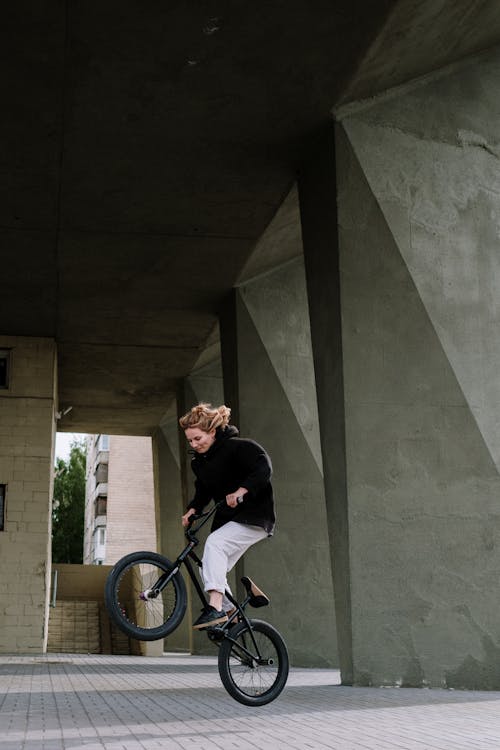 A Woman in Black Long Sleeve Shirt Riding a Bicycle