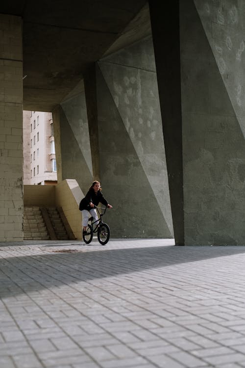 A Woman in Black Jacket Riding a Bicycle