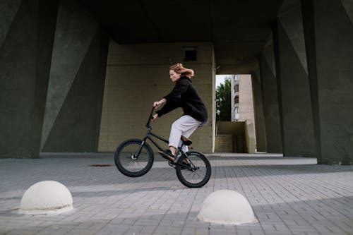 A Woman in Black Jacket Riding a Bicycle