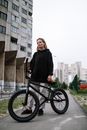 Woman in Black Long Sleeve Shirt and Blue Denim Jeans Riding on Black Bicycle