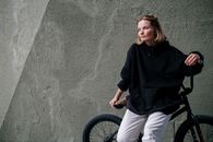 Girl in Black Hoodie and White Pants Riding Bicycle