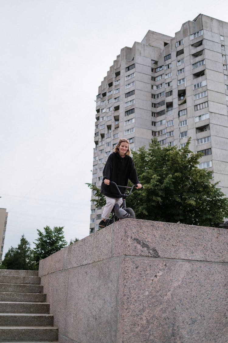 Happy Woman In Black Sweater Riding A Bicycle 