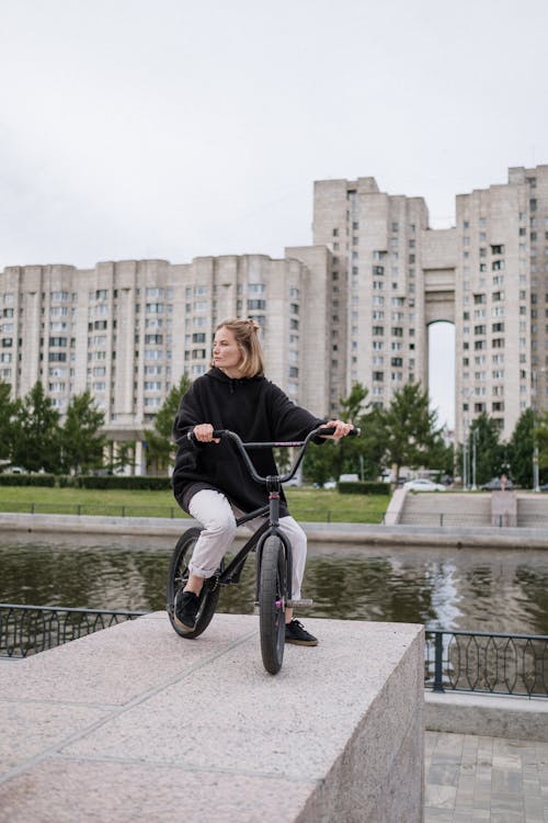 A Woman in Black Jacket Riding a Bicycle