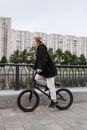 Woman Wearing a Black Hoodie Riding a Bicycle