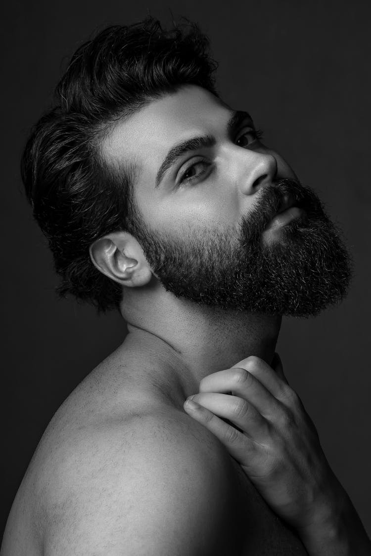 Bearded Man With Trendy Hairstyle Touching Neck