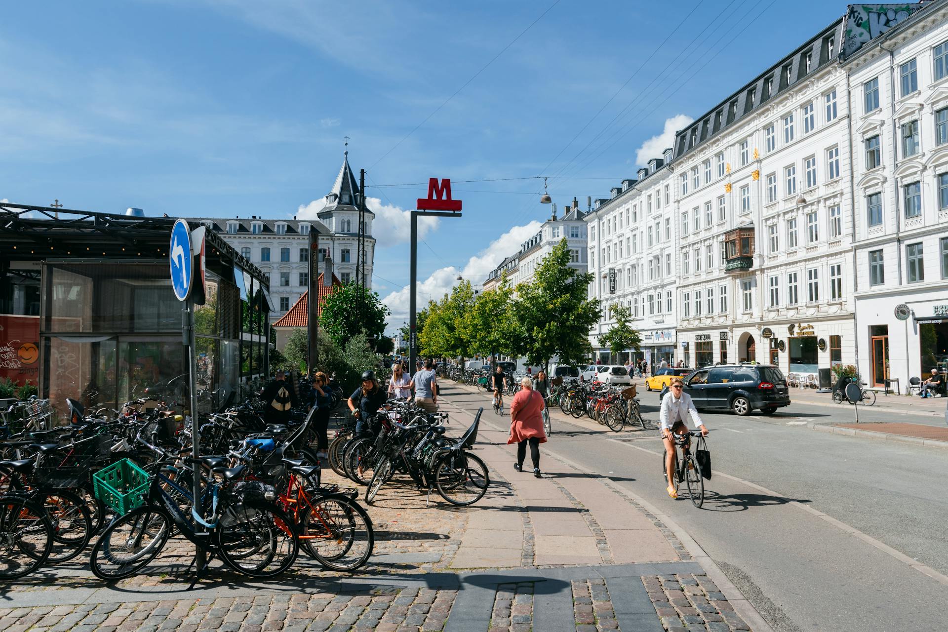 Bicyclists and pedestrians in a lively Copenhagen street, showcasing urban life.