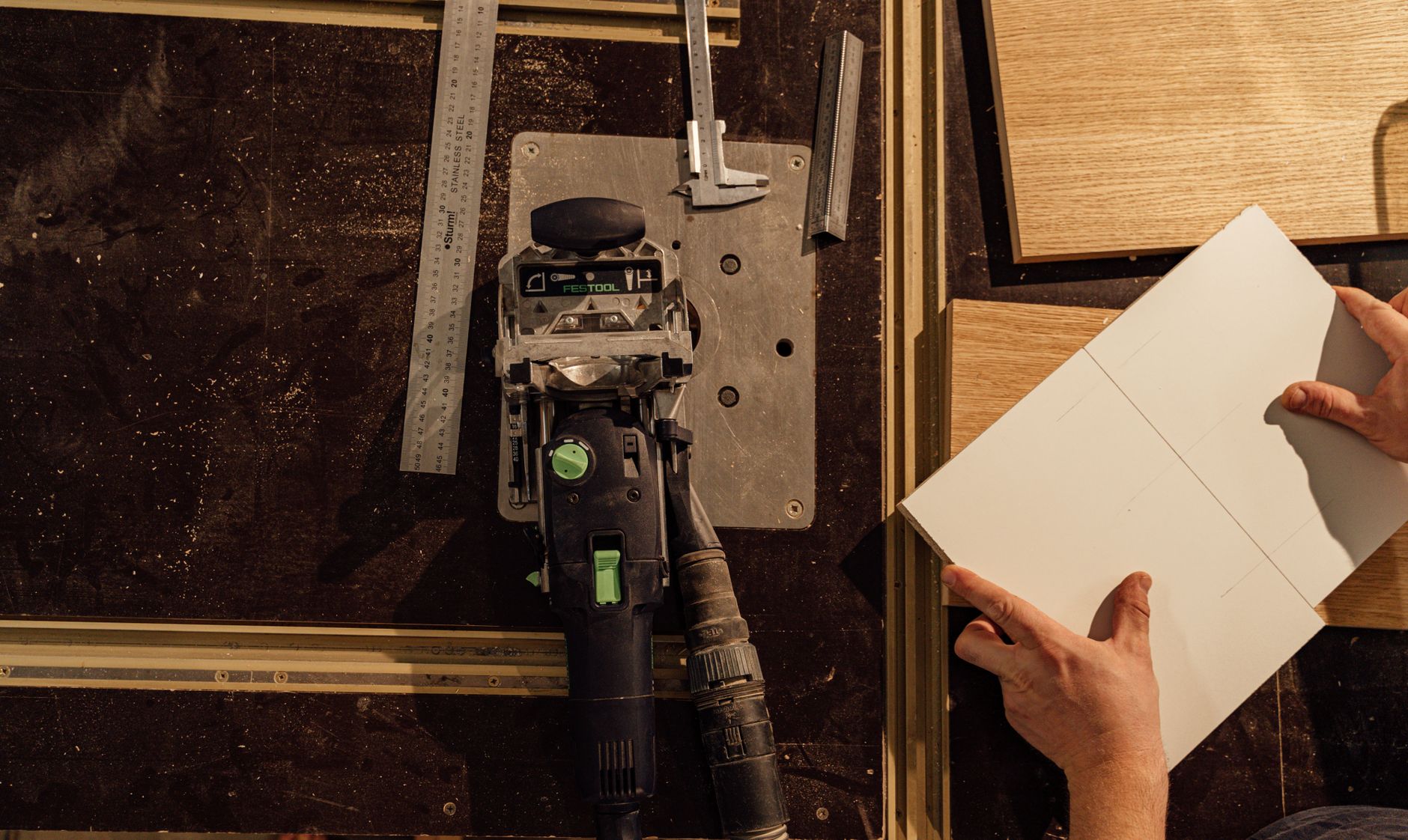 Detailed image showcasing a woodworker's tools and hands in an indoor workshop setting.