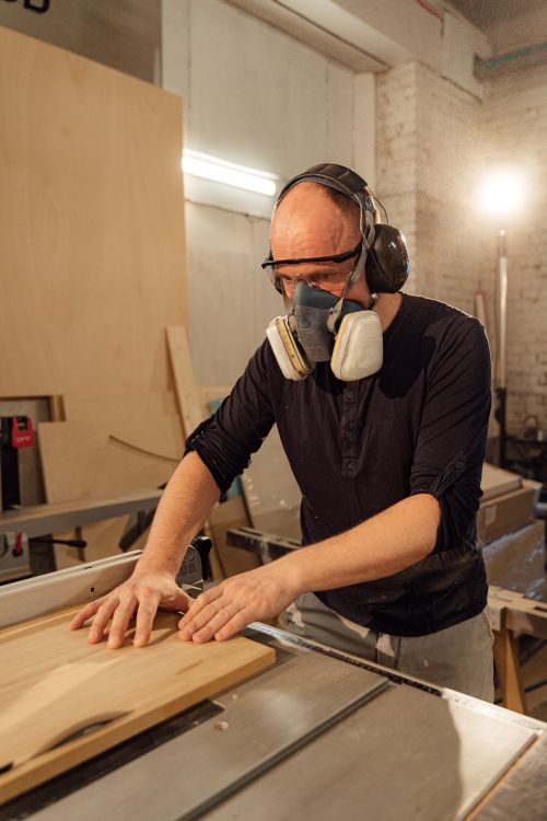 Free An adult male woodworker shaping wood with precision in a well-lit workshop. Stock Photo