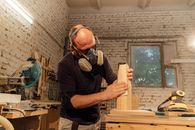 Man in Black Crew Neck T-shirt Wearing Black Headphones Holding Brown Wooden Box