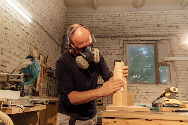 Carpenter sanding a finished wooden piece