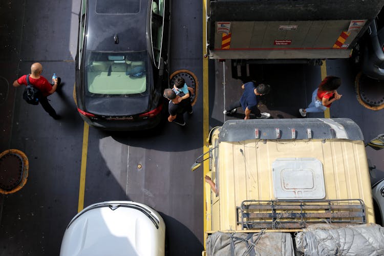 Top View Shot Of People Crossing The Road Between Vehicles