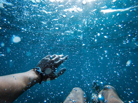 A captivating underwater scene featuring a hand and bubbles, evoking a sense of exploration.