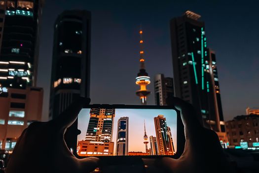 Mobile photography showcasing the architectural beauty of Kuwait City skyline at night.