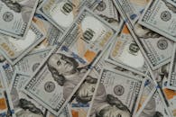 美国100美元钞票的特写零散分布，突出了财富和货币的概念