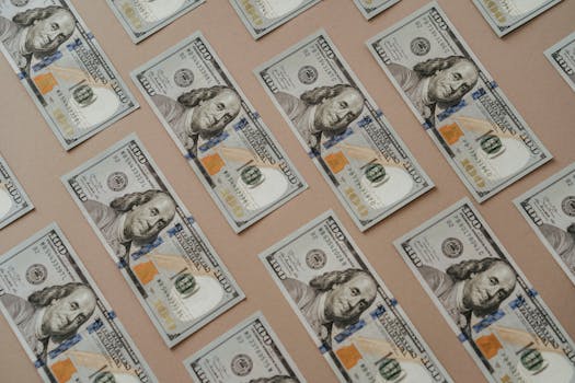 Close-up of multiple US dollar bills arranged in a grid pattern.