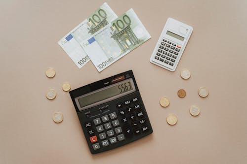 Free Black and Silver Calculator Beside Silver Coins Stock Photo