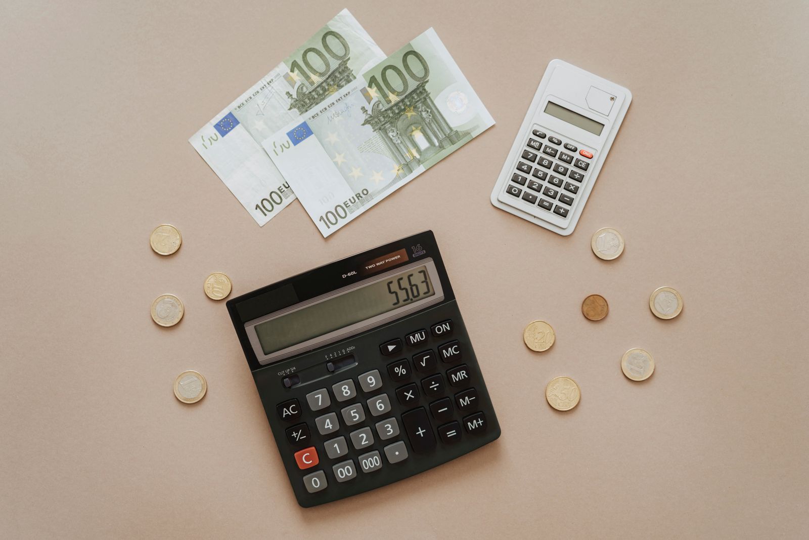 Calculadora y monedas de euro para controlar gastos, deuda y presupuesto