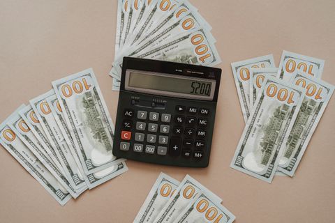 Calculator lying next to U.S. dollar bills