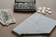 Black and Gray Calculator Beside White Printer Paper