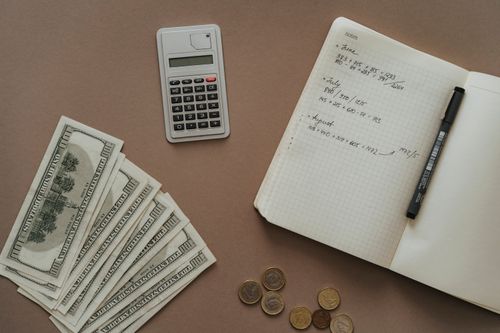 Free Flat lay with calculator, notebook, and US dollars ideal for financial concepts. Stock Photo