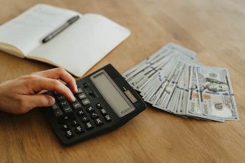 Free A Person Holding Black Desk Calculator Stock Photo