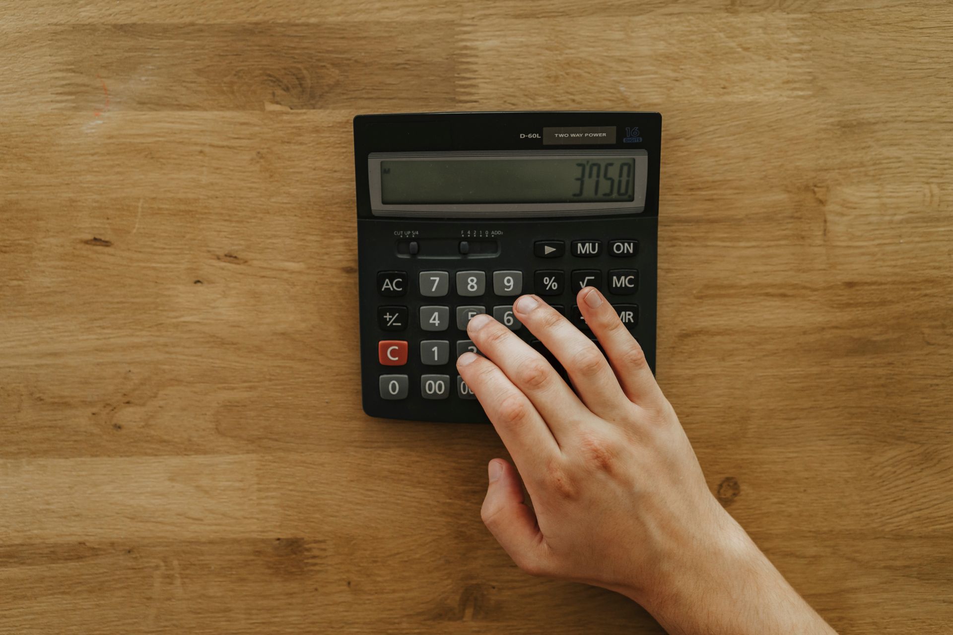 A Person Holding Black Desk Calculator