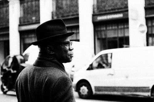 Free Vintage black and white photo of a man wearing a hat walking on a street in Paris. Stock Photo