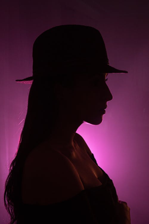 Foto profissional grátis de chapéu fedora, dentro de casa, iluminado por trás