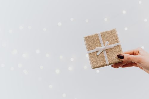 Free A close-up of a hand holding a glittering gift box with a ribbon, perfect for Christmas or festive occasions. Stock Photo