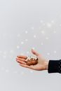一只喜庆的、覆盖着白雪的饼干被握在手中，背景明亮