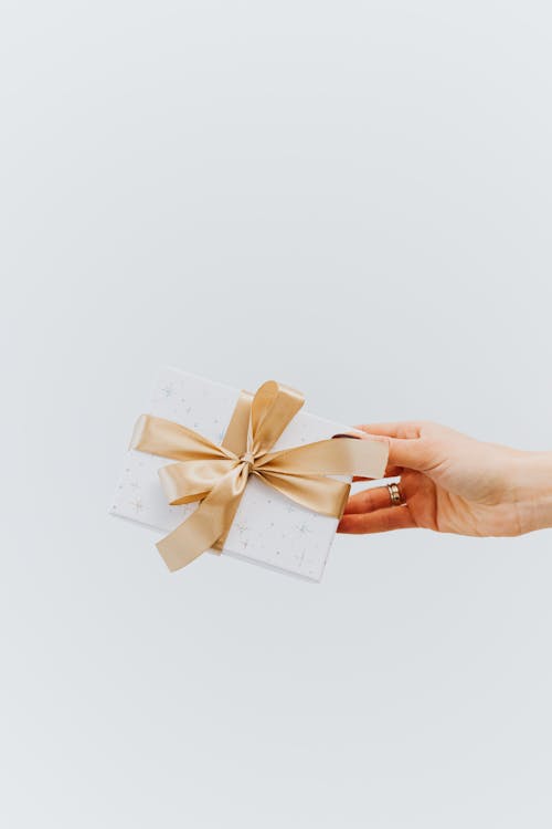 Free Person Holding White a Present with Ribbon Stock Photo