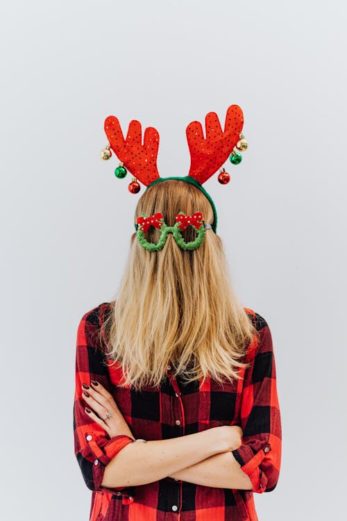Free A Person in Red Plaid Shirt Wearing a Reindeer Headband Stock Photo