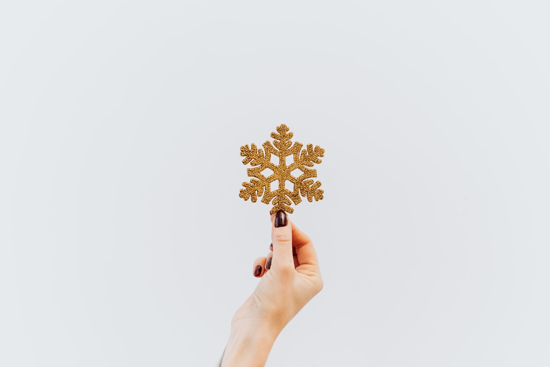 Person Holding Golden Paper Snowflake