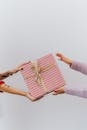 两个人交换了一个包装精美的礼品盒，盒子上有红色条纹和金色缎带