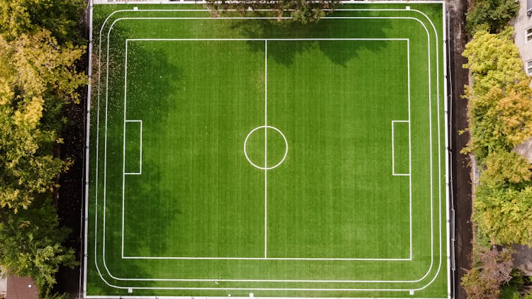 Football Field Surrounded By Green Trees