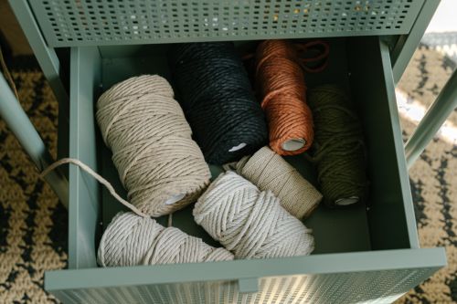 Free Top view of various yarn rolls stored in a metal drawer, perfect for textile crafts and embroidery projects. Stock Photo