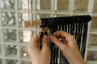 Person Weaving the Yarns